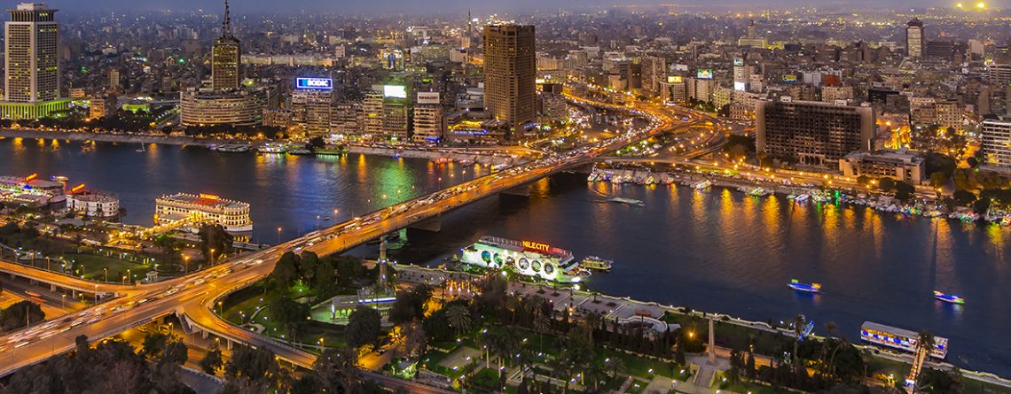 Panoramic view of Cairo cityscape and Nile River at dusk.