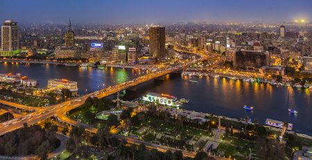 Panoramic view of Cairo cityscape and Nile River at dusk.