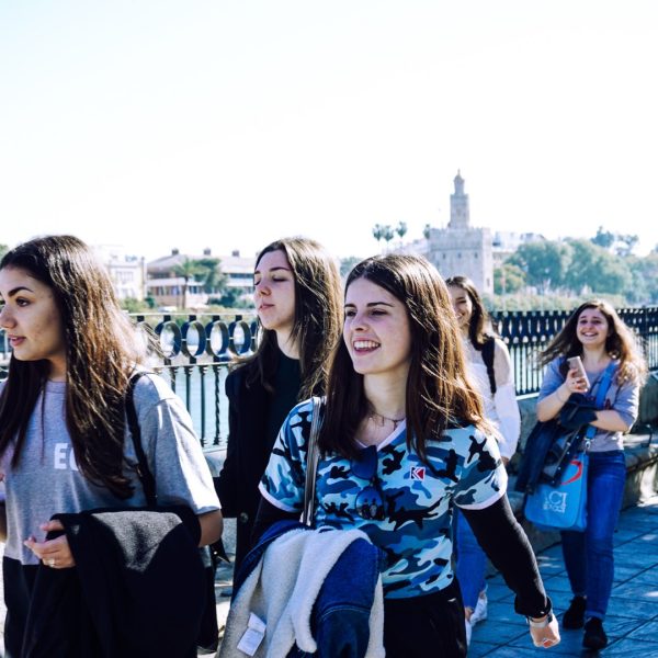 Group of young people walking outdoors on a sunny day.