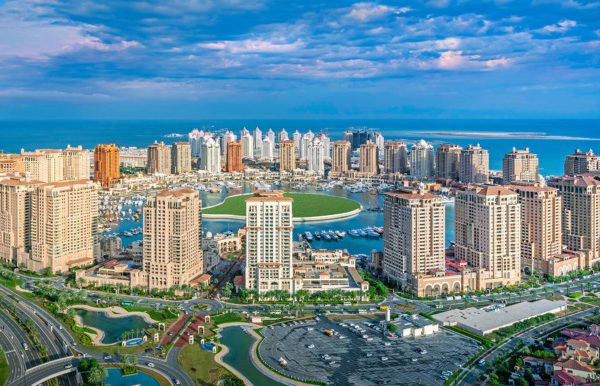 Panoramic view of a modern coastal city with skyscrapers and marina.