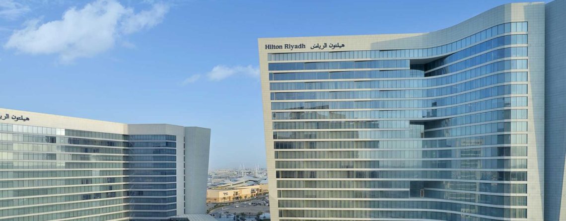 Modern Hilton Riyadh hotel with glass facade under blue sky