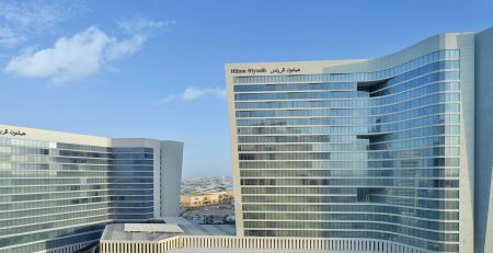 Modern Hilton Riyadh hotel with glass facade under blue sky