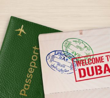 Passport with Dubai entry stamps and welcome sign.