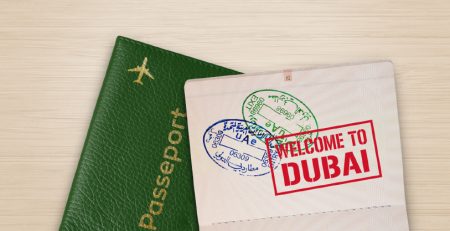 Passport with Dubai entry stamps and welcome sign.