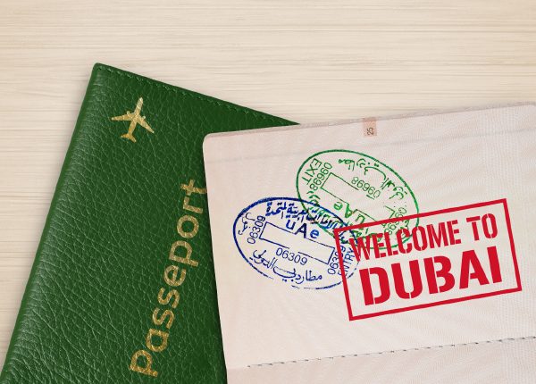 Passport with Dubai entry stamps and welcome sign.
