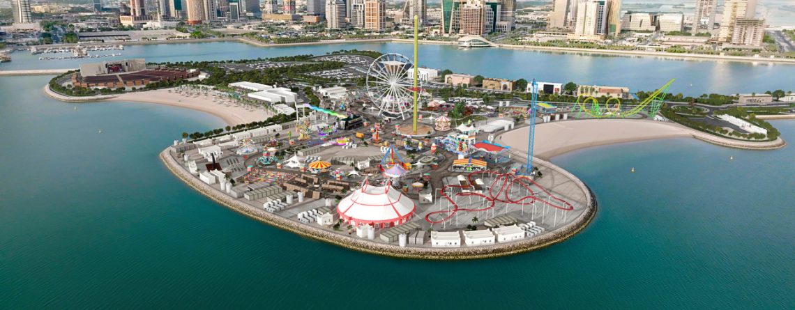 Aerial view of an amusement park on an island with a city skyline in the background.