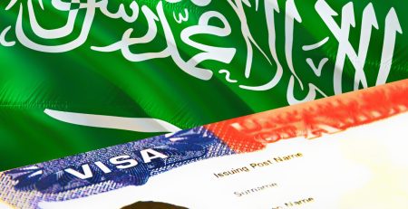 Saudi Arabian flag with a visa document in the foreground.