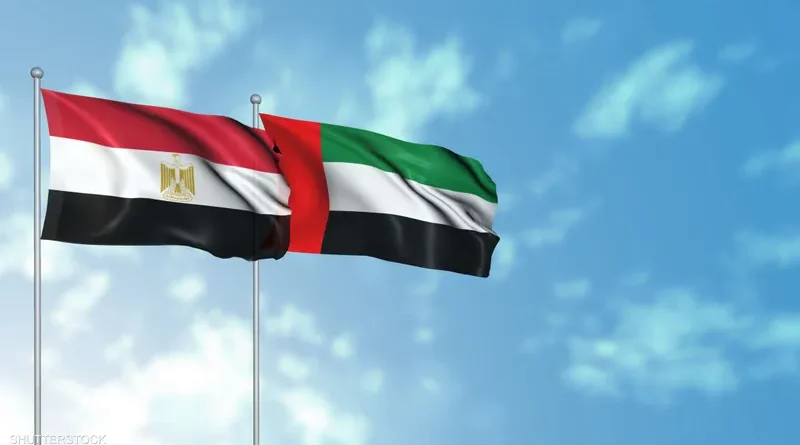 Egyptian and UAE flags waving against a blue sky.