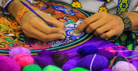 Artisan crafting colorful embroidery in Dubai handicraft center.