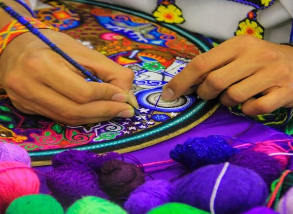 Artisan crafting colorful embroidery in Dubai handicraft center.