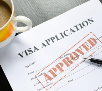 Visa application form with approved stamp and pen.